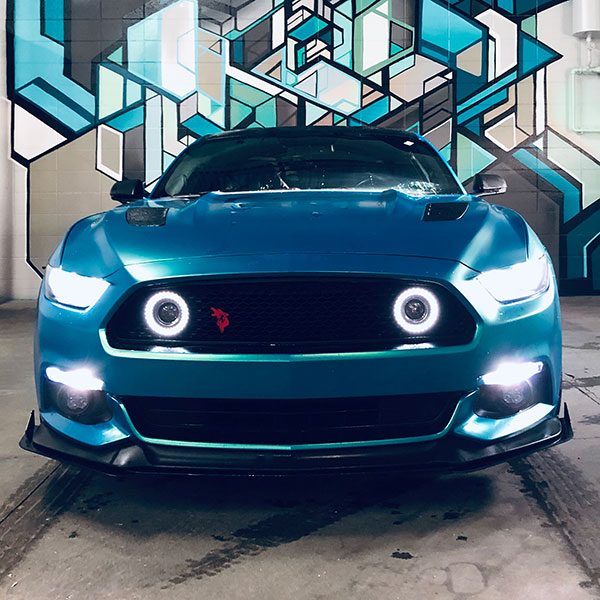 blue car in front of graffiti art at Arthur's Car Wash