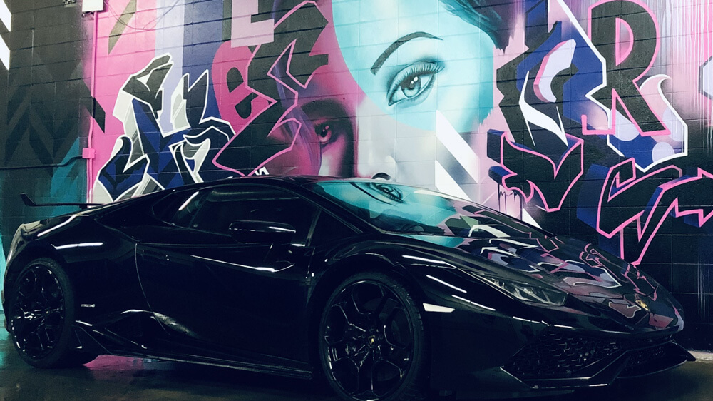 Lamborghini in front of graffiti art